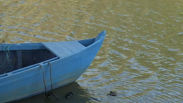 Image of a part of a blue craft boat, embarked on the river