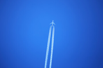 青空を飛行機が飛んでいく