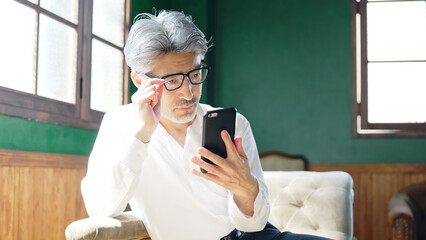 スマホを使うシニア男性