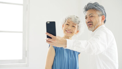 スマホで自撮りするシニアカップル