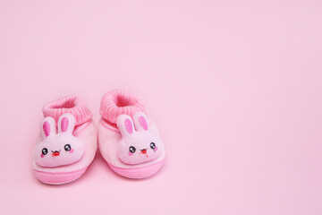 booties in the form of hares on a pink background with copy space