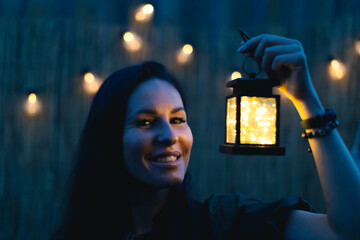 An attractive woman with a retro flashlight at dusk. Front view. - obrazy, fototapety, plakaty