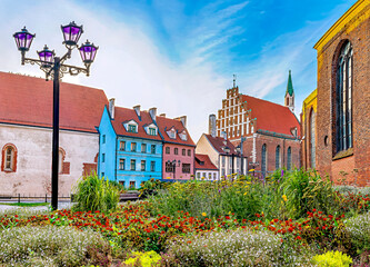 Colorful flowers, buildings and medieval Evangelical Lutheran Church of Saint John the Baptist in old Riga, Latvia