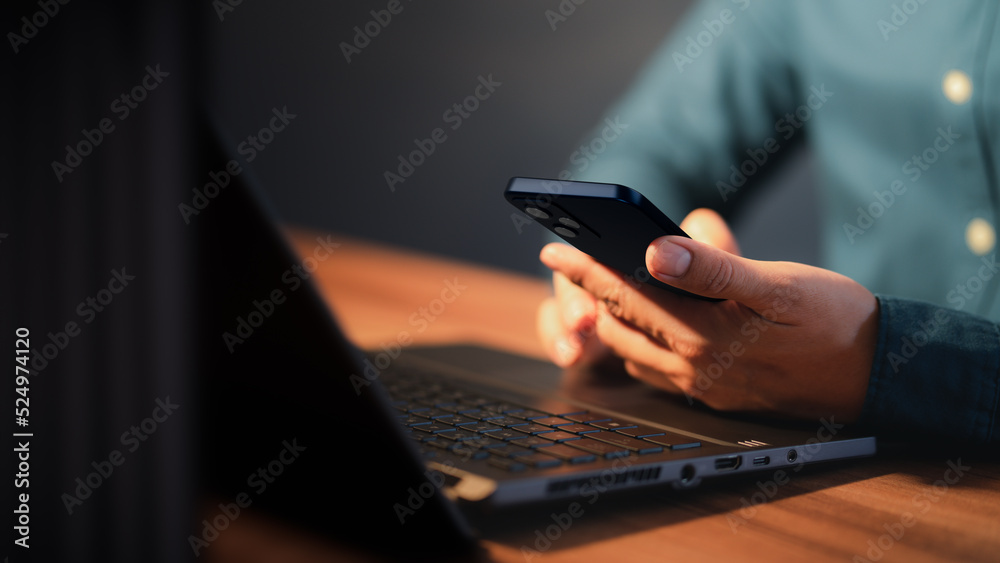 Poster Closeup image of a man holding and using mobile phone or smartphone.