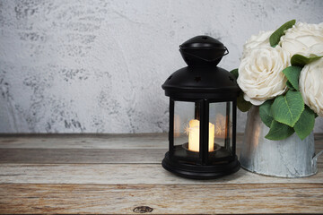 Obraz na płótnie Canvas Black Lantern with LED candle light home decoration on wooden background