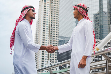 Arab Businessman Muslim dress shaking hands together. Muslim Men Teamwork business partner...