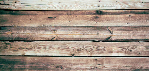 Obraz premium Dark background of wooden planks, burned and folded horizontally. The boards are old, damaged. Sepia picture.