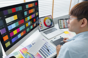 Creativity concept, Male graphic designer using tablet and looking color swatch samples on screen