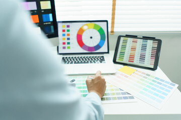 Creativity concept, Male graphic designer choosing color swatch samples on document and designing