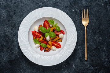 Grilled peach salad with mozzarella, tomato, green basil and sauce, close up, top view