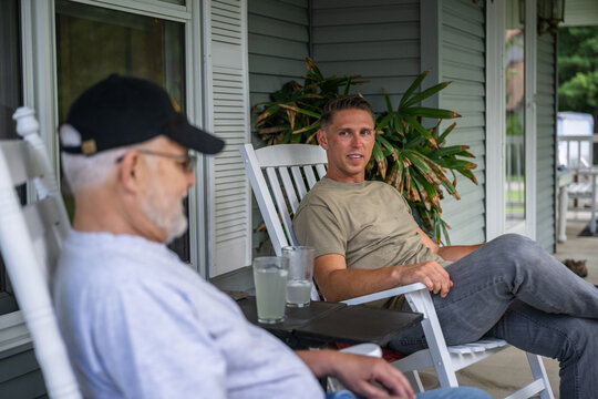 Air Force service member talks with his veteran father-in-law on the porch.