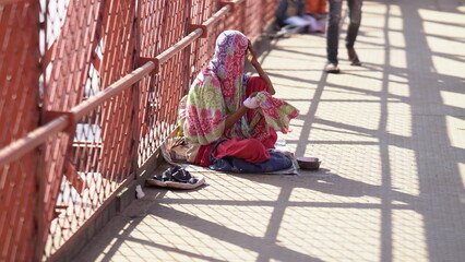 Fototapeta na wymiar lady beggar sitting aside of road.