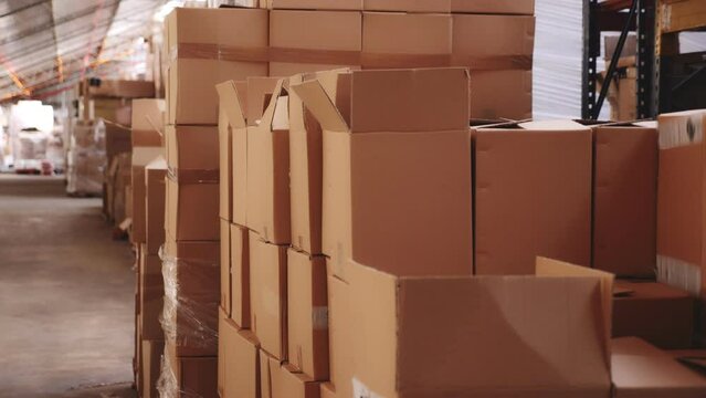 Rows of pasteboard boxes on racks in storehouse. Boxes on shelves in warehouse.