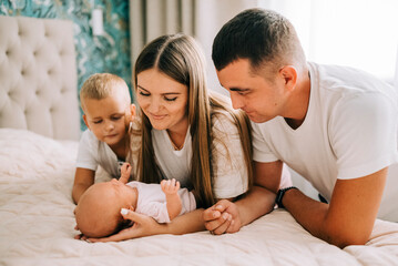 Newborn baby with happy parents and brother. Happy family. Healthy newborn baby with mom and dad. Mother, father and infant baby. Cute Infant girl and parents