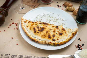 fried large cheburek in a white plate
