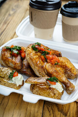 fried chicken legs in a disposable dish with potatoes

