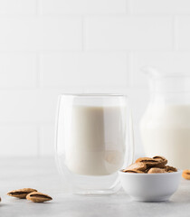 Organic almond milk in a glass on a light background. Alternative to dairy products. Copy space