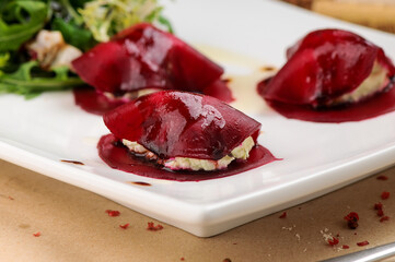 tomato ravioli with meat in a white plate
