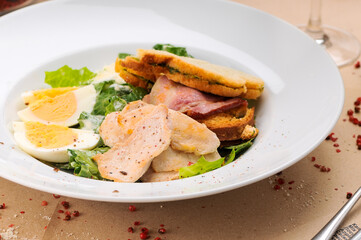 caesar salad in an autor style serving in a white plate, macro photo
