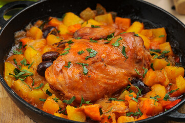 fried chicken fillet in a black pan in a sauce with vegetables macro photo
