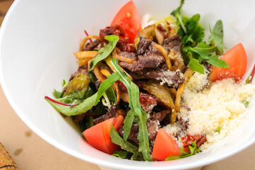 warm salad with veal in a white plate with
