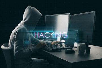 Side view of hacker at desktop using computers with abstract creative digital text hologram on dark background. Hacking, technology and ai concept.