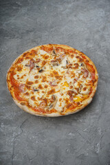 pizza with bacon and mushrooms on a gray background, vertical photo
