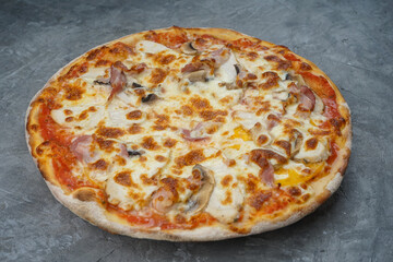 pizza with bacon and mushrooms on a gray background macro photo
