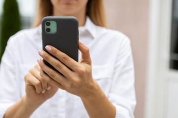 female hands hold a modern mobile phone on the street..education, modern app, shopping order, work online