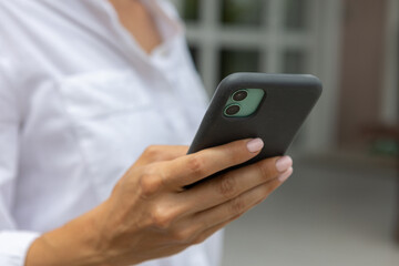 female hands hold a modern mobile phone on the street..education, modern app, shopping order, work online