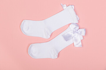 high white children's socks for girls with big bows for party wear on a pink background