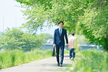 外を歩くビジネスマンの後ろ姿