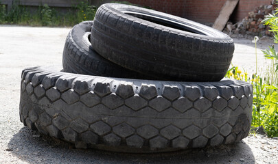 Old used tires of cars and trucks are piled up and stored for recycling. Old tire collection stored...