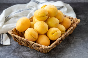 Ripe apricots on a dark background. Fresh and juicy apricots in the basket. Organic food. close up