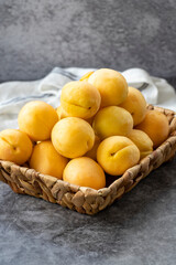 Ripe apricots on a dark background. Fresh and juicy apricots in the basket. Organic food. close up