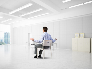 young businessman meditating in the office