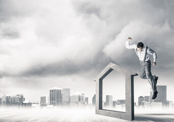 Manager man crashing stone home as symbol for real estate insurance