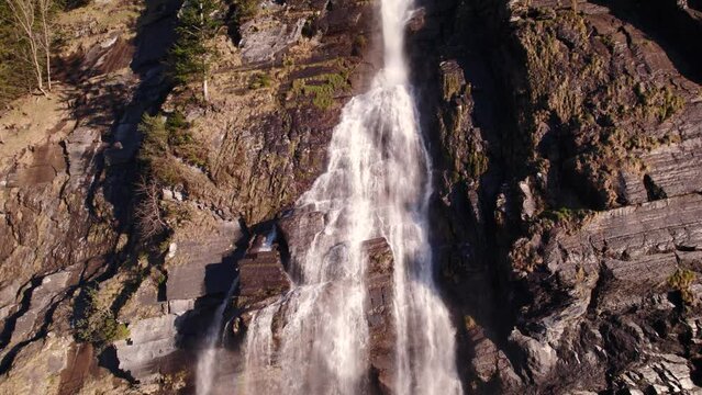 aerial drone footage raising down a picturesque waterfall (Fallbach) in Grindelwald in the Swiss Alps