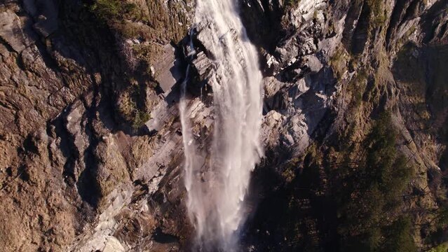 aerial drone footage raising up and turning left with stunning views of Fallbach, a waterfall in Grindelwald in Switzerland