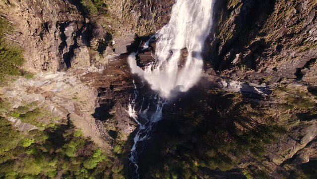 aerial drone footage with top down views of a picturesque waterfall in spring in Grindelwald in the Swiss Alps