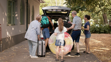 People putting luggage and trolleys inside car while getting ready for citybreak departure. Big...