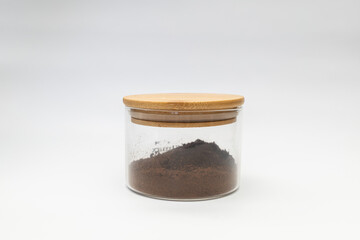 Ground coffee in a jar on a white background