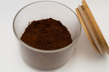 Ground coffee in a jar on a white background