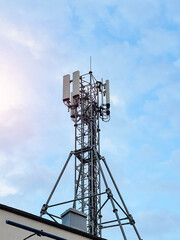 Macro Base Station. 5G radio network telecommunication equipment with radio modules and smart antennas mounted on a metal against cloulds sky background. Telecommunication tower of 4G and 5G cellular.