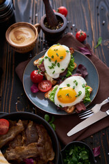 Tasty breakfast - fried egg toasts, bacon, tomatoes on wooden kitchen table