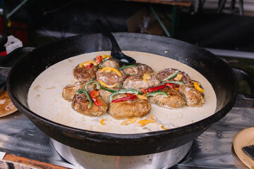Cooking in a large cauldron dishes. Delicious food cooked over an open fire, which is offered at a...