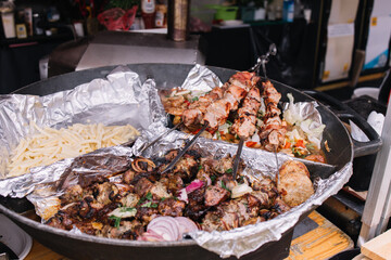 Cooking meat large cauldron dishes. Delicious food cooked over an open fire, which is offered at a...