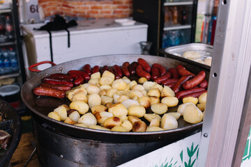 Cooking in a large cauldron dishes. Delicious food cooked over an open fire, which is offered at a...