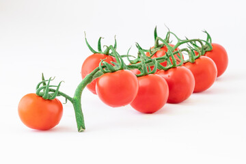 Delicious and rich tomatoes on a branch with drops of water, isolated on a white background. Agricultural harvest and daily healthy food