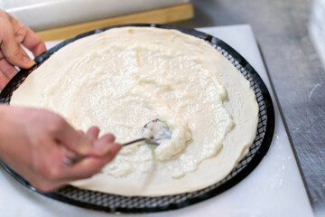 クリーム系ピッツァを厨房で作成中
